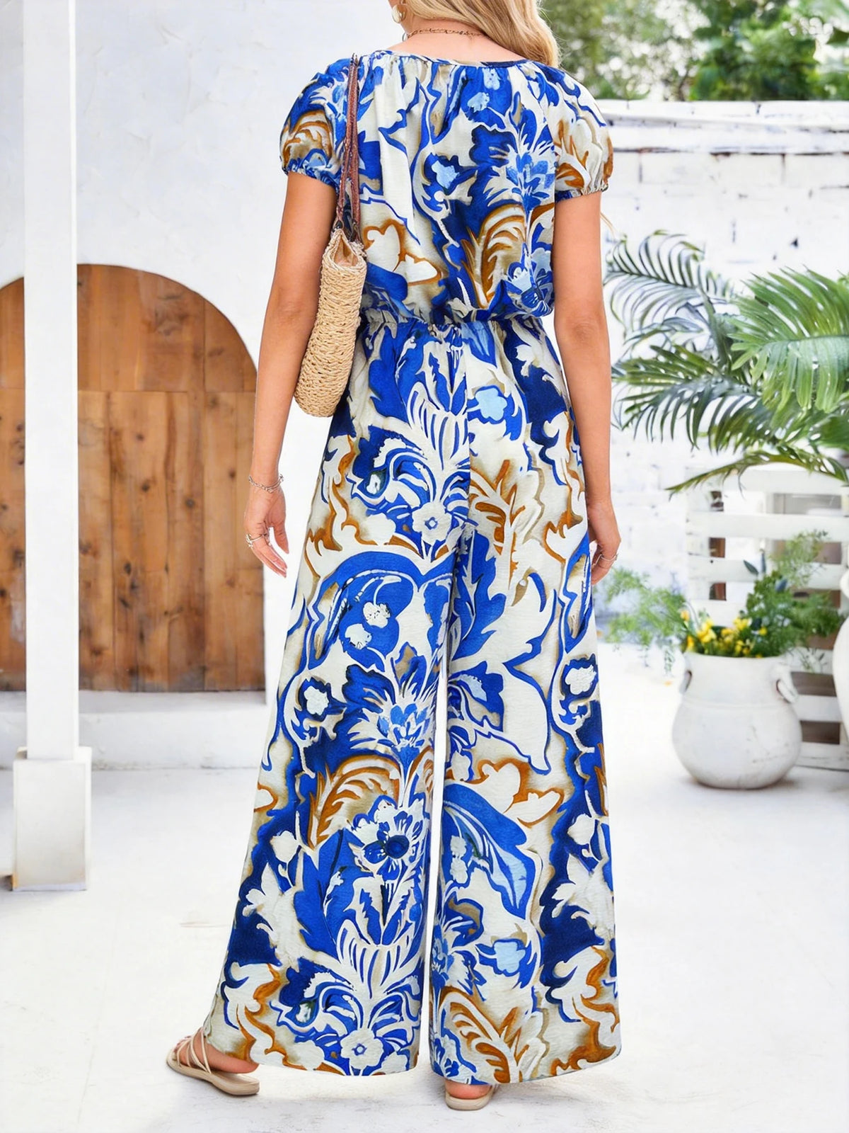 Blauer Vintage-Jumpsuit mit Blumenmuster, Rundhalsausschnitt, kurzen Flatterärmeln, Knopfleiste vorne, Kordelzug an der Taille und weitem Bein für Damen