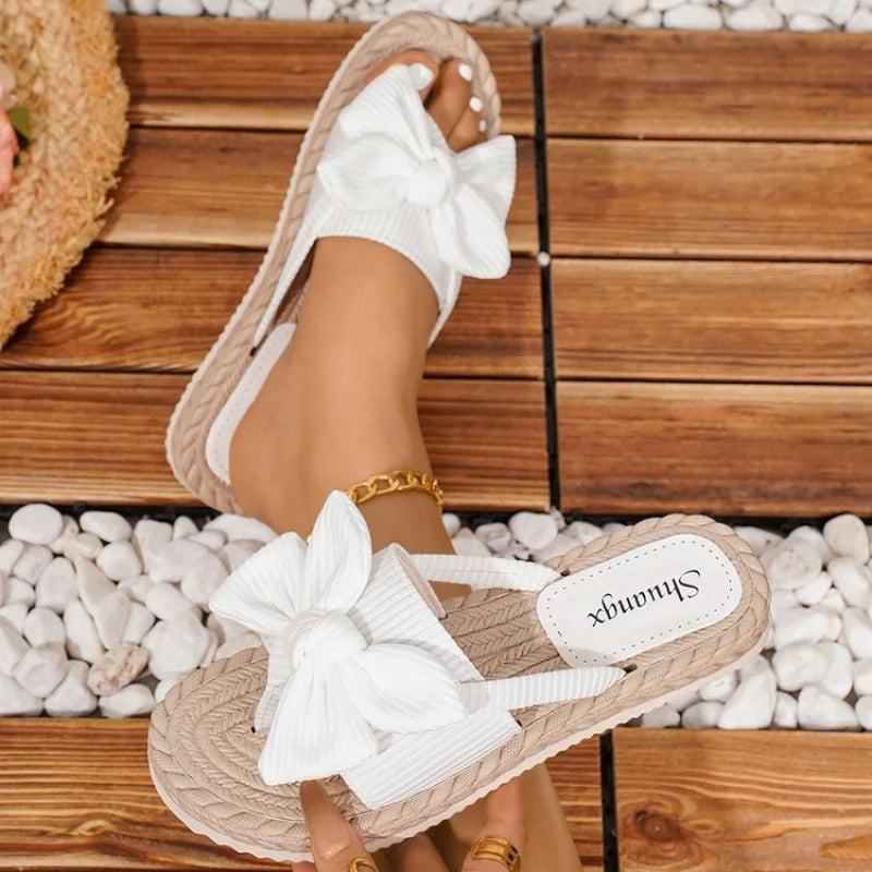 Flache Slip-On-Sandalen für Damen mit weicher Sohle und Obermaterial-Design, verziert mit Schleifendetails, sowohl stilvoll als auch vielseitig.